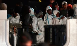 Des migrants attendent pour débarquer du navire italien Diciotti, le 20 juin 2018 à Pozzallo, en Sicile