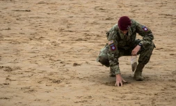 Un soldat américain recueille du sable à Omaha Beach, en Normandie, le 5 juin 2019