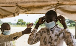 Un agent sanitaire à la frontière du poste de Busunga, entre l'Ouganda et la République démocratique du Congo, prend la température d'un voyageur à l'aide d'un thermomètre infrarouge sans contact à Bundibugyo, le 18 mai 2026.