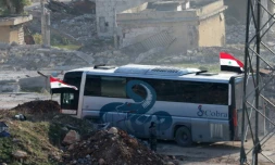Un bus au passage de Ramoussa, sous contrôle des forces gouvernementales syriennes dans le sud d'Alep, le 18 décembre 2016 dans le cadre d'une opération d'évacuation de civils et de soldats rebelles  