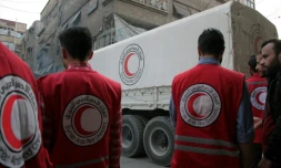 Des membres de la Croix-Rouge syrienne s'apprêtent à décharger des camions transportant des cartons d'aides humanitaires, le 12 novembre 2017 à Douma, dans la Ghouta orientale
