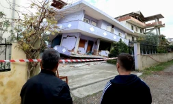 Des Albanais observent une maison effondrée le 28 novembre 2019 à Durres sur la côte Adriatique après un séisme meurtrier