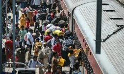 Des habitants tentent de monter dans un train surchargé à la gare de Jammu, le 10 mai 2025 au Cachemire indien