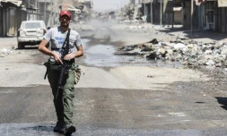 Un membre des forces irakiennes patrouille dans un quartier de Mossoul repris à l'EI, le 23 juin 2017 
