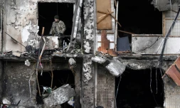 Un soldat ukrainien consate les dégùts dans un immeuble endommagé par des tirs russes à Kiev, le 26 février 2022