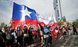Des manifestants agitant un drapeau géant chilien, à Santiago du Chili le 23 octobre 2019