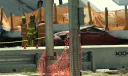 Des secouristes s'affairent autour d'une voiture coincée sous le manteau d'un pont piétonnier qui s'est effondré jeudi à Miami