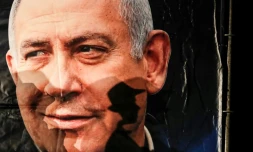 L'ombre d'un passant se projette sur un portrait du Premier ministre israélien Benjamin Netanyahu, à Jérusalem, le 11 décembre 2019