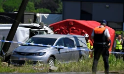 Un corbillard stationné sur le site d'un accident entre un train et un bus scolaire, au passage à niveau de Vierhuizen à Buggenhout, au nord de Bruxelles, le 26 mai 2026 en Belgique