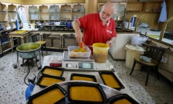 Hassan al-Makari pèse la mfatka dans son échoppe à Beyrouth,  le 29 août 2024 au Liban