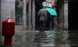 Un homme marche dans une rue inondée de Venise le 17 novembre 2019