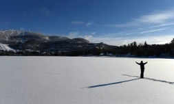 Un homme pose pour une photo sur le lac Tremblant dans la région des Laurentides au Québec, Canada, au pied du Mont Tremblant le 24 décembre 2017