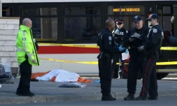 Des policiers prÚs d'un corps caché par un drap, le 23 avril 2018 à Toronto, au Canada, aprÚs qu'un homme au volant d'une camionnette a fauché une dizaine de piétons