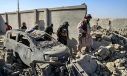 Des membres de la sécurité talibane marchent à cÎté d'une voiture endommagée, le 16 octobre 2025 dans le district de Spin Boldak