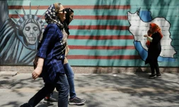 Des Iraniennes passent devant la façade de l'ancienne ambassade des Etats-Unis à Téhéran le 7 août 2018.