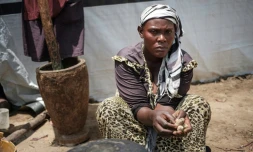 Amissa Irakoze cuisine devant sa tente du camp de déplacés de Gatumba, dans le nord-ouest du Burundi le 15 mars 2022