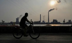 Promenade à vélo en Chine le long du fleuve Huangpu, près de la centrale électrique au charbon de Wujing, à Shangaï, le 28 septembre 2021 