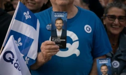 Un sympathisant tient un tract à l'effigie du chef du Parti québécois (PQ), Paul St-Pierre Plamondon, devant la Maison de Radio-Canada à Montréal, dans la province de Québec au Canada, le 23 septembre 2026