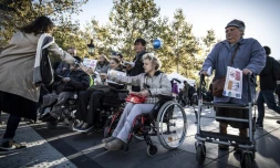 Des militants distribuent leurs revendications devant une station de métro à Paris, lors d'une manifestation de l'association APF France Handicap, le 26 septembre 2018