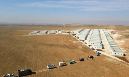 Vue aérienne d'un convoi de déplacés syriens arrivant au complexe résidentiel, construit près de la ville d'al-Bab, le 9 février 2022 en Syrie 