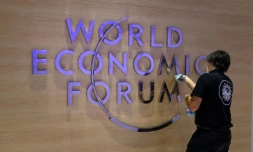 Une employée nettoie le logo du Forum économique mondial (WEF) à l'intérieur du centre des congrès de Davos, en Suisse, le 22 mai 2022