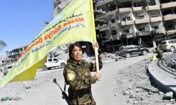 Rojda Felat, une commandante des Forces démocratiques syriennes, brandit le drapeau de son groupe à Raqa le 17 octobre 2017