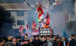 Des enfants, maquillés et habillés de costumes bordés et colorés, en parade, debout sur des palanquins, dans les rues de Luofang, le 11 février 2017 dans l'est de la Chine