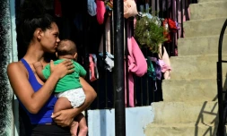 Une femme porte un bébé, à La Fortaleza près de Cucuta, en Colombie, le 9 janvier 2026