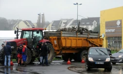 Des agriculteurs français bloquent l'accÚs à un hypermarché avec leurs tracteurs et leurs remorques chargées de déchets à Quimper, le 2 février 2016