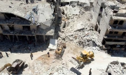 Les secouristes s'activent au pied d'un immeuble détruit par un bombardement, à Maaret al-Noomane, dans le nord-ouest de la Syrie, le 22 juillet 2019