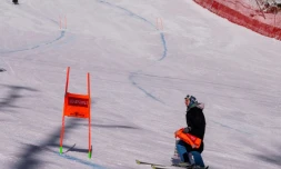 Un officiel (d) inspecte la piste de la descente féminine de Rosa Khutor en Russie, le 1er février 2020  