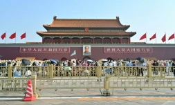 Des personnes marchent devant le portrait de Mao Tsé-toung sur la place Tiananmen, le 4 juin 2024 à Pékin