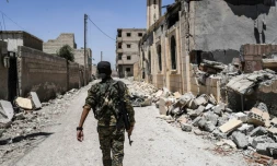 Un soldat des Forces démocratiques syriennes (FDS), alliance arabo-kurde soutenue par Washington, dans une rue détruite de Raqa, le 12 juillet 2017