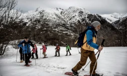 Des randonneurs en raquettes suivent leur guide de moyenne montagne dans la station des Deux-Alpes (IsÚre), le 4 février 2021