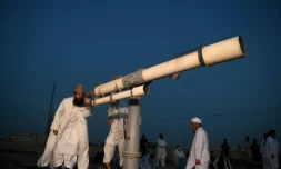 Un dignitaire religieux, Maulana Abdul Khabeer Azad, regarde à travers un télescope pour déterminer la date du début du ramadan, à Karachi le 23 avril 2020