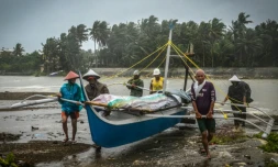Des pêcheurs mettent un bateau à l'abri avant l'arrivée du typhon Phanfone, à Baybay (Philippines) le 24 décembre 2019