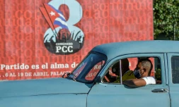 Une vieille voiture américaine face à une affiche du 8e congrÚs du Parti communiste cubain, à La Havane le 6 avril 2021