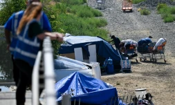 Des employés d'une association d'aide aux sans-abris veillent sur un campement de SDF, à Los Angeles, le 1er juin 2026