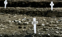 Croix marquant les tombes de personnes mortes du Covid-19 mais dont les corps n'ont pas été réclamés, dans le cimetiÚre Maggiore à Milan, le 23 avril 2020