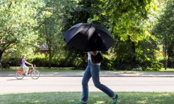 Une personne s'abrite du soleil avec un parapluie, le 22 juin 2026 Ă Hyde Park, Ă Londres