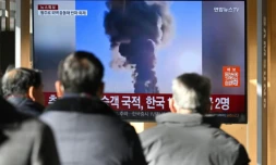 Des gens regardent les images de l'accident d'avion à l'aéroport international de Muan, dans une gare de Séoul, le 29 décembre 2024
