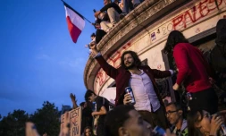 Un homme le poing levé lors d'un rassemblement au soir du second tour des législatives place de la République à Paris, le 7 juillet 2024
