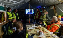 Des gilets jaunes regardent le président Emmanuel Macron à la télévision, le 10 décembre 2018 au Mans
