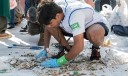 Un membre de l'équipe indienne participant au premier monidal Spogomi ramasse des mégots dans une rue de Tokyo, le 22 novembre 2023