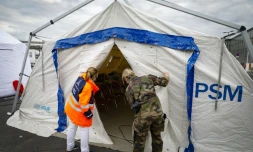 Une employée de l'aéroport d'Orly et une militaire française inspecte une tente équipée pour soigner des patients infectés par le nouveau coronavirus, le 3 avril 2020 au sud de Paris