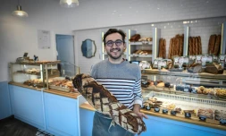 Un boulanger pose dans sa boutique Ă Paris le 27 novembre 2020