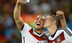 Bastian Schweinsteiger (d) et Lukas Podolski font un selfie après la victoire de la Mannschaft face à l'Argentine en finale du Mondial, le 13 juillet 2014 à Rio 