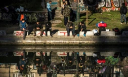 Des migrants assis au bord du quai de Jemmapes, dans le nord de Paris, le 31 octobre 2016