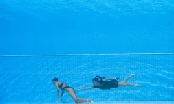 L'entraîneure de l'équipe américaine de nage artistique et synchronisée Andrea Fuentes (d) vient sauver sa nageuse Anita Alvarez qui a perdu connaissance lors des Mondiaux de natation, à Budapest, le 22 juin 2022