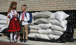 Des écoliers ukrainiens font leur rentrée devant des sacs de sable protégeant leur école, à Lviv en Ukraine le 1er septembre 2023